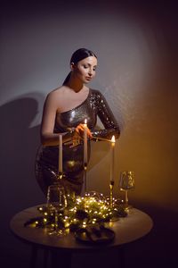 Portrait of young woman standing by christmas tree