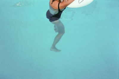 Low section of woman swimming in sea