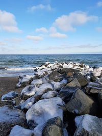 Rocks on beach against sky