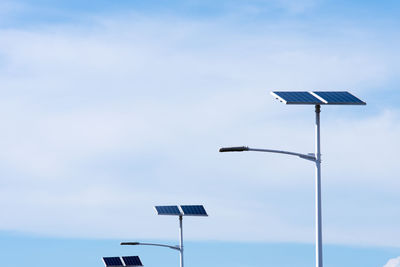 Low angle view of street light with solar panels against sky