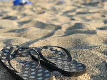 High angle view of flip-flops at sandy beach