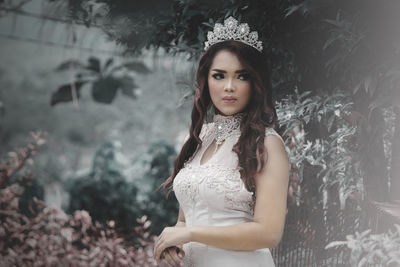 Beautiful young woman wearing tiara while standing outdoors