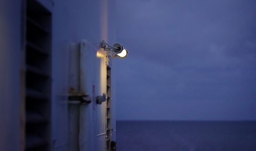 Close-up of illuminated light against sea at night