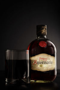 Close-up of wine glass on table against black background