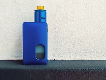 Blue electronic cigarette against wall