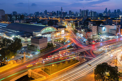 High angle view of illuminated city street and buildings against sky