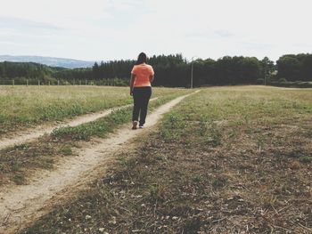 Rear view of man walking on field