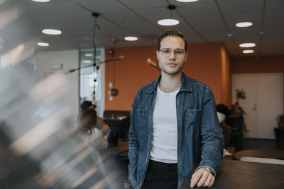 Portrait of confident young businessman standing in office