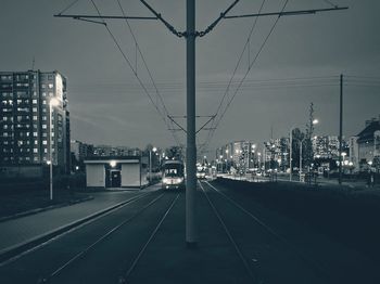 Railroad tracks in city against sky