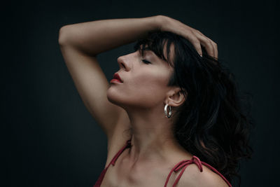 Portrait of beautiful young woman against black background