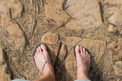 Feet in minimal sandals on stony path