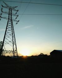 Low angle view of silhouette electricity pylon against sky