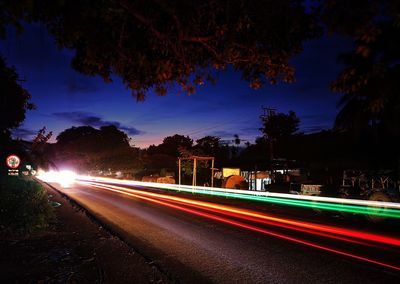 Light trails on road at sunset