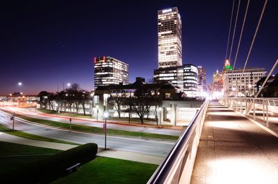 Illuminated city buildings against clear sky at night