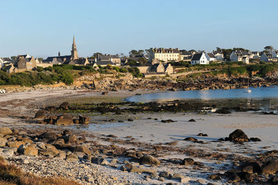 Scenic view of beach and buildings against clear sky