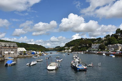 Sailboats moored on sea against buildings in city
