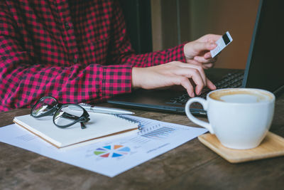 Man holding coffee cup on table