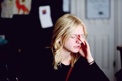 Close-up of young woman suffering from headache