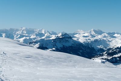 Scenic view of snowcapped mountains against clear blue sky