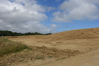 Scenic view of sandy field against sky