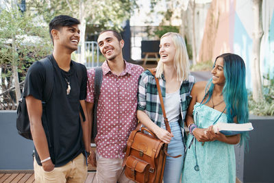 Smiling friends standing in campus