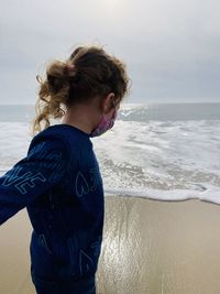 Midsection of woman at beach against sky