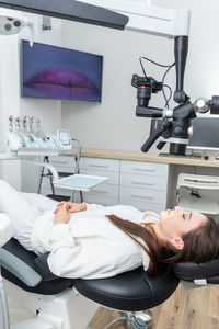 Rear view of doctor operating patient at clinic