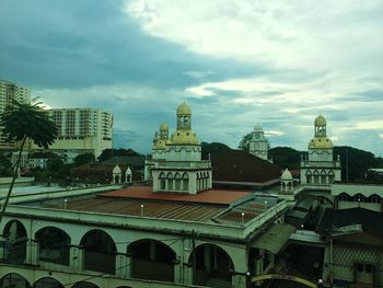 View of cityscape against cloudy sky
