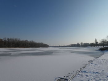 Scenic view of snow covered field against clear sky