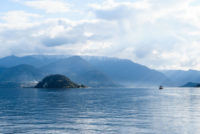 Scenic view of sea and mountains against sky