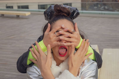 Woman covering friend eyes in city