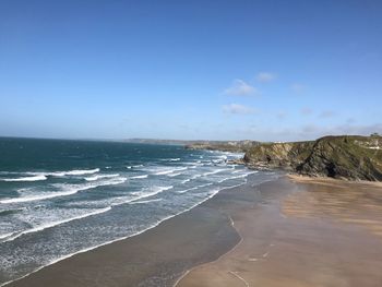 Scenic view of beach against blue sky