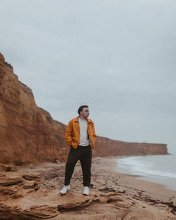 Full length of man standing at beach against clear sky