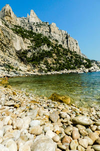 Rocks in sea against clear sky