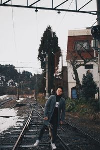 Man standing on railroad track against sky