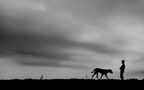 Silhouette men on field against sky