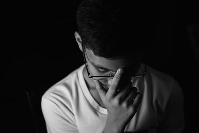 Close-up of boy against black background