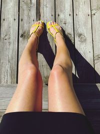 Low section of woman sitting on wooden floor