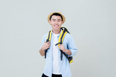 Portrait of smiling man standing against white background