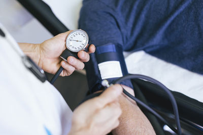 Close-up of doctor checking patient blood pressure at hospital