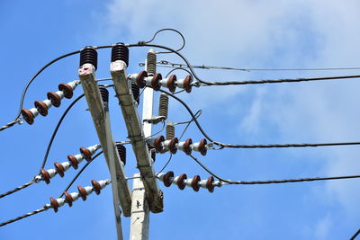 Low angle view of telephone pole against sky