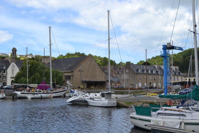 Sailboats moored at harbor