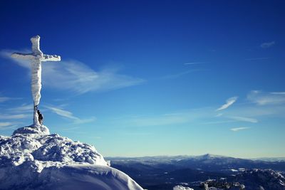 Low angle view of cross on mountain against sky