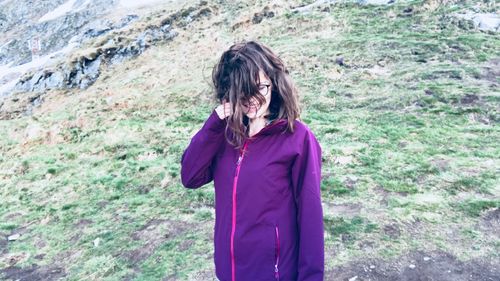 Portrait of woman standing against purple wall