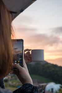 Solo woman use phone take photo during drink coffee with relax and wellbeing feel with mountain 