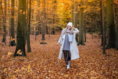 Woman standing in forest during autumn