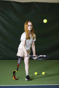 Girl with artificial leg playing tennis