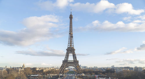 Eiffel tower against cloudy sky