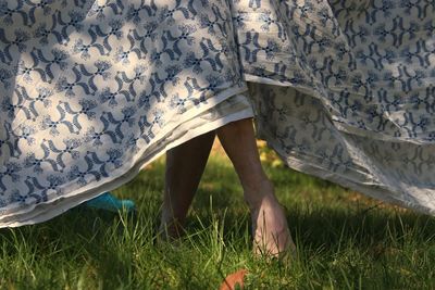 Low section of woman standing on field