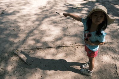 Full length of girl pointing while standing on land